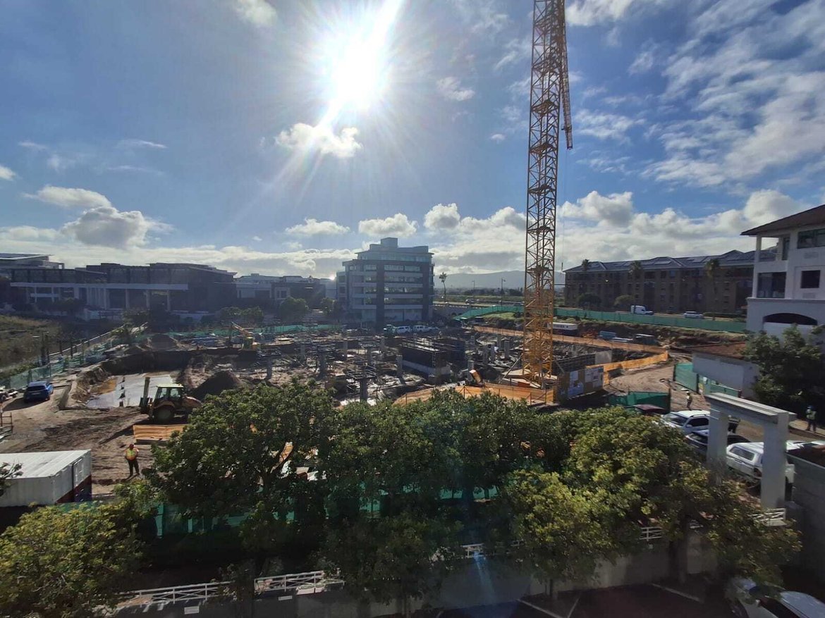 Canal Plaza under construction in Century City, Cape Town, with a tower crane and surrounding commercial buildings in the background.